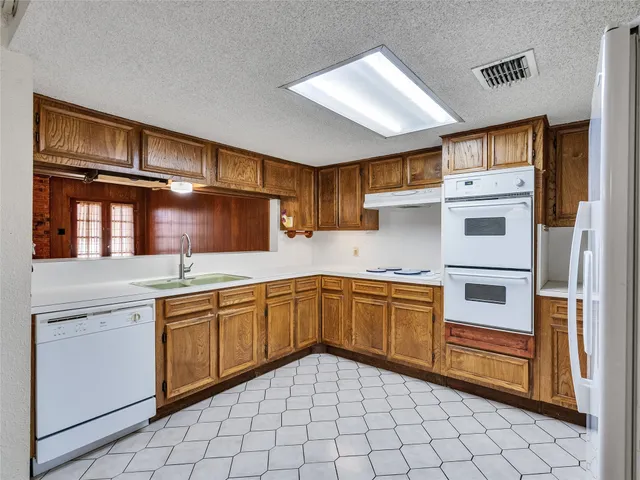 a kitchen with stainless steel appliances granite countertop a sink and cabinets