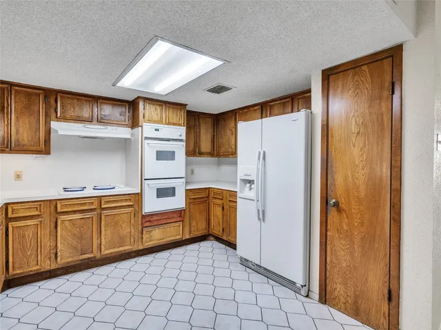 a kitchen with stainless steel appliances granite countertop a refrigerator and a sink