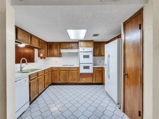 a kitchen with stainless steel appliances a sink and a refrigerator