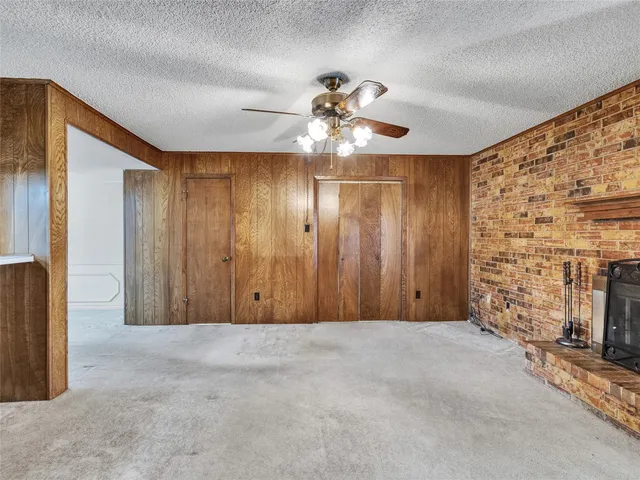 a view of a livingroom with a ceiling fan and a fireplace