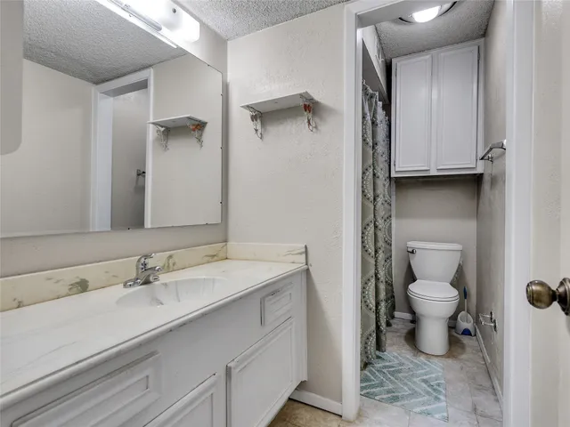 a bathroom with a sink toilet and a mirror
