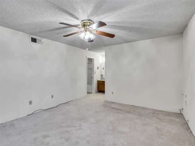 an empty room with chandelier fan
