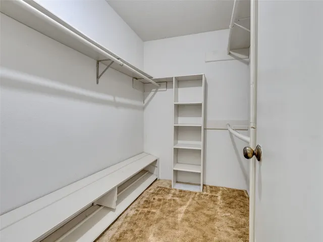 a view of walk in closet with empty racks