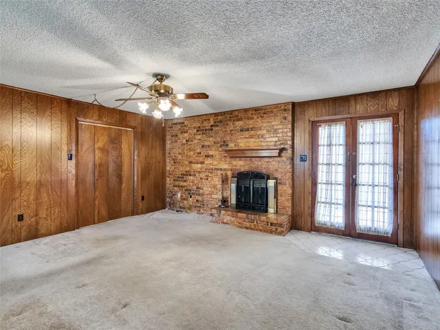 a view of an empty room with a fireplace and a window