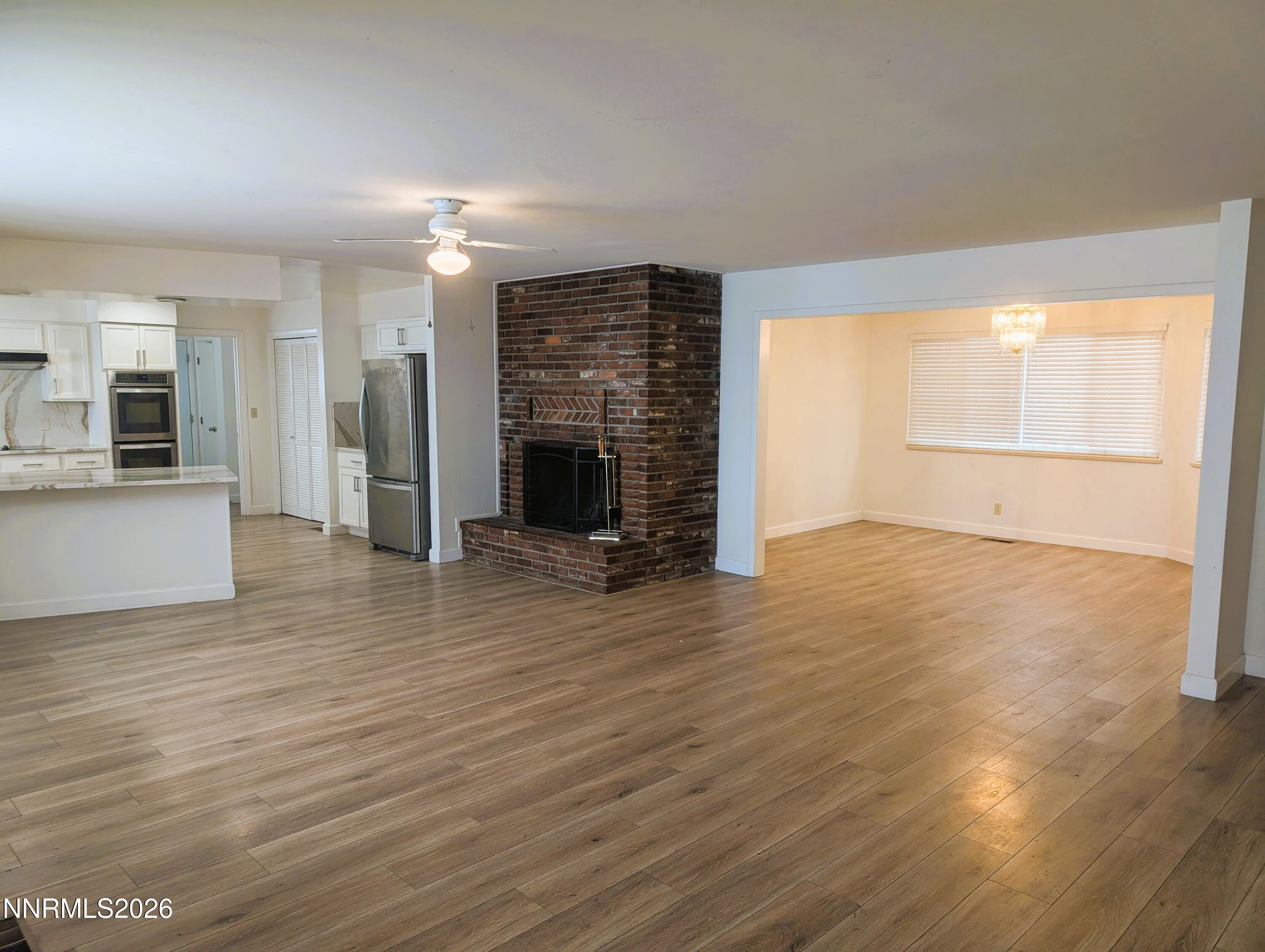 2390 Barnes Circle Reno, NV 89509 - Photo 2 of 13 an empty room with wooden floor and windows