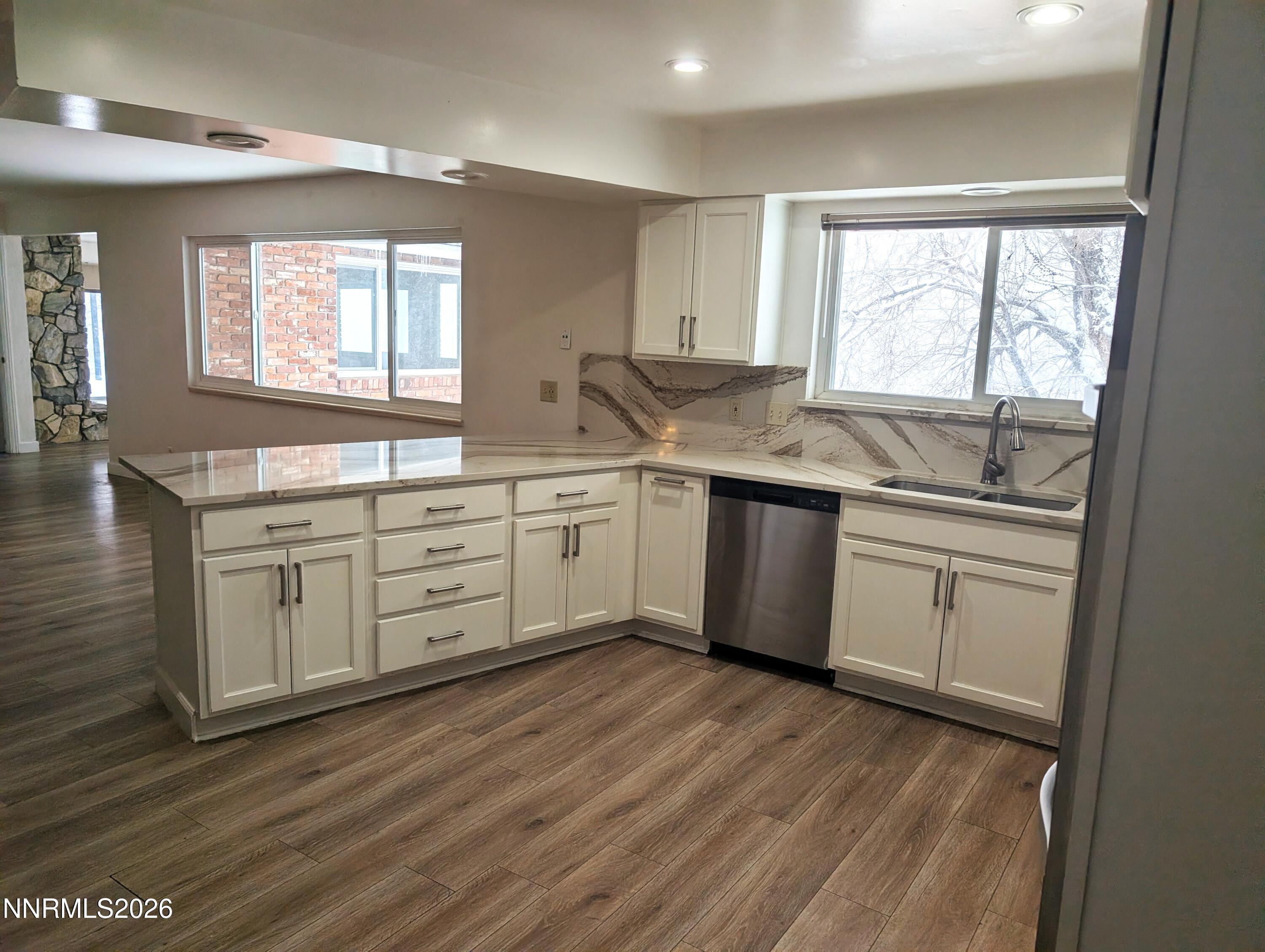 2390 Barnes Circle Reno, NV 89509 - Photo 4 of 13 a kitchen with stainless steel appliances granite countertop a stove a sink and white cabinets with wooden floor