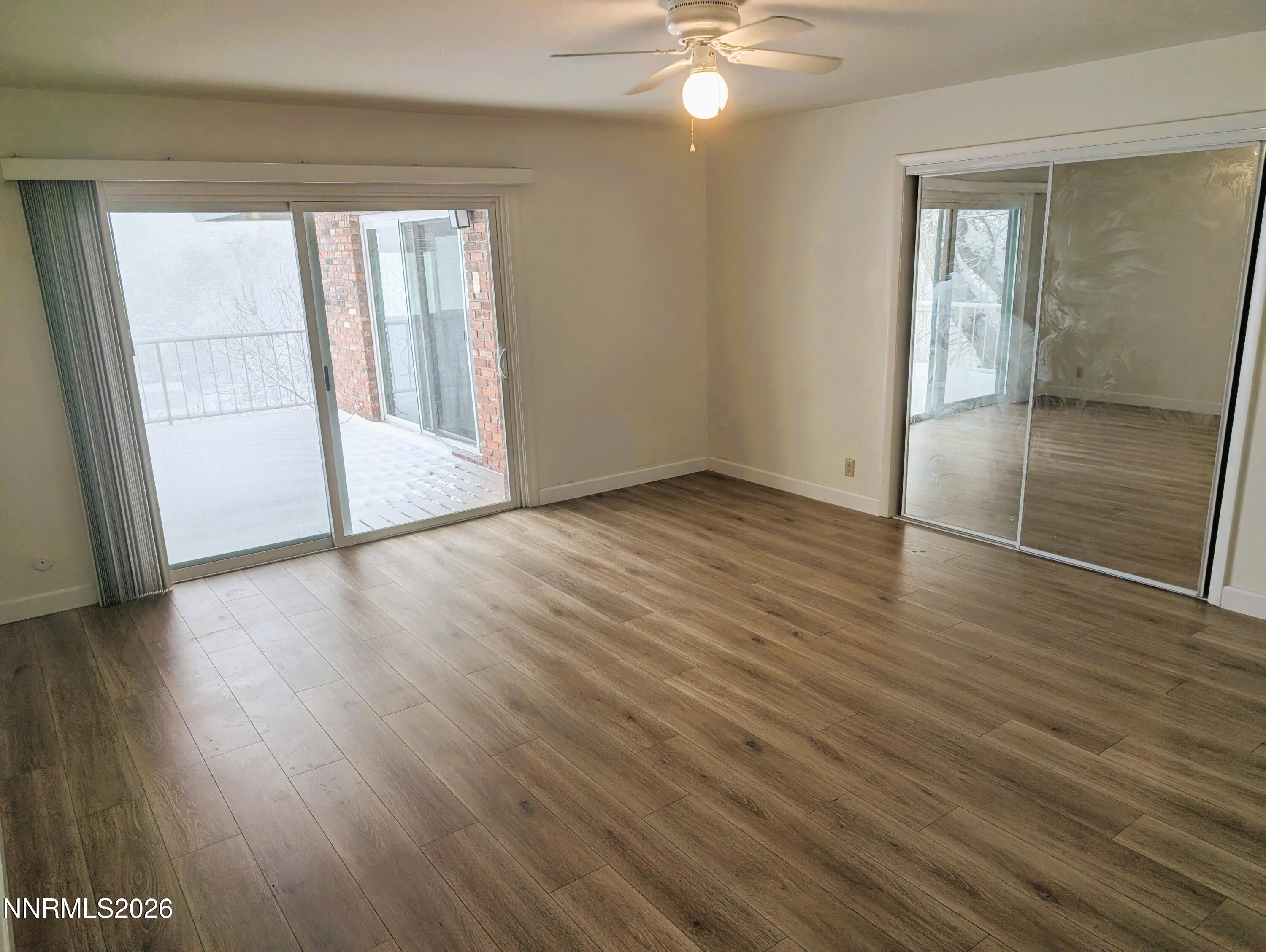 2390 Barnes Circle Reno, NV 89509 - Photo 8 of 13 an empty room with wooden floor and windows