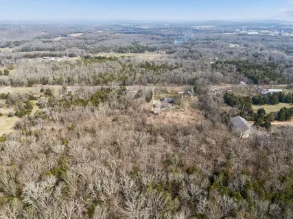 an aerial view of house with yard and mountain view in back