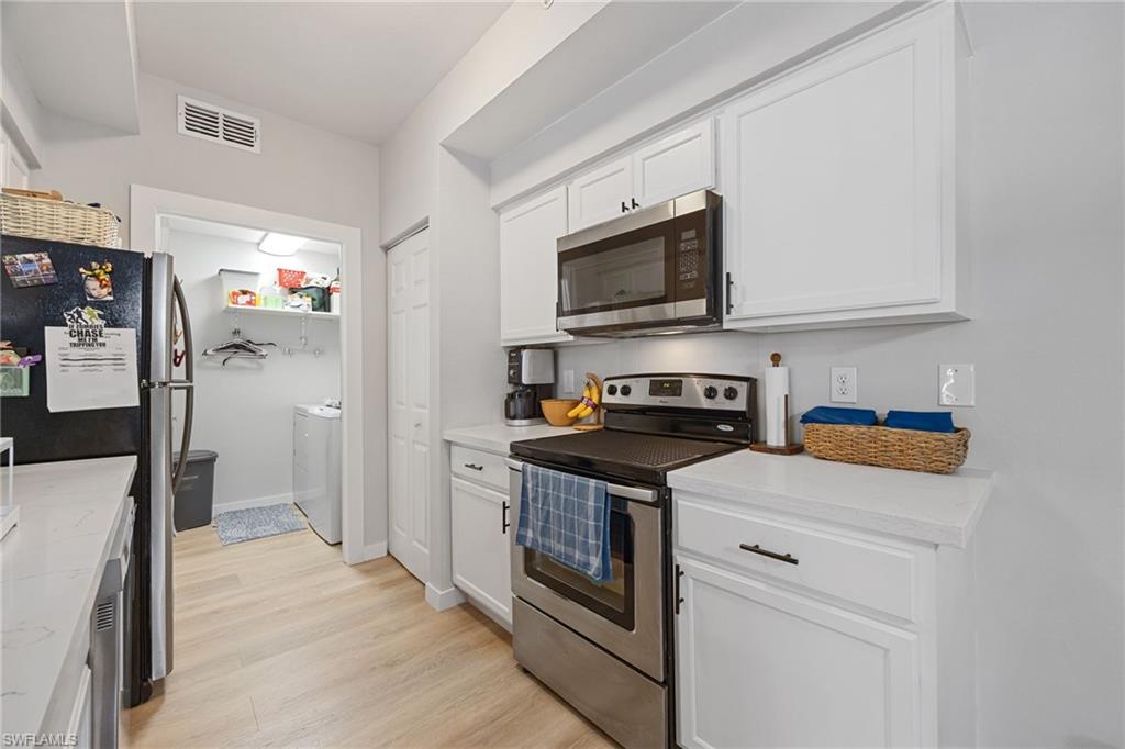 4710 St Croix Lane, Unit 216 Naples, FL 34109 - Photo 10 of 29 a kitchen with stainless steel appliances granite countertop a refrigerator and a stove top oven