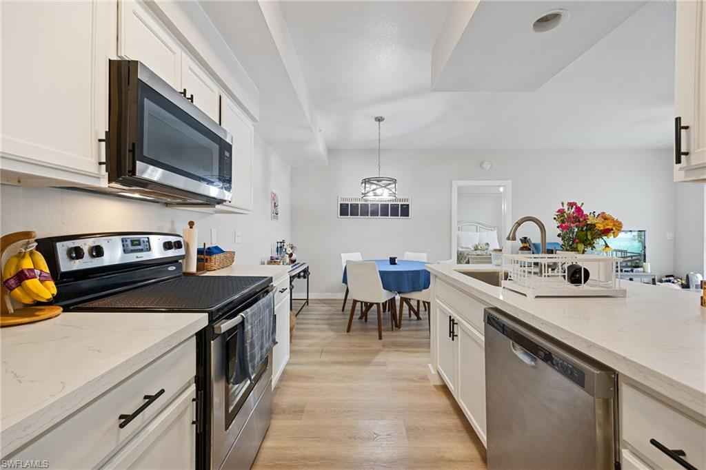 4710 St Croix Lane, Unit 216 Naples, FL 34109 - Photo 11 of 29 a kitchen that has a sink and a stove in it