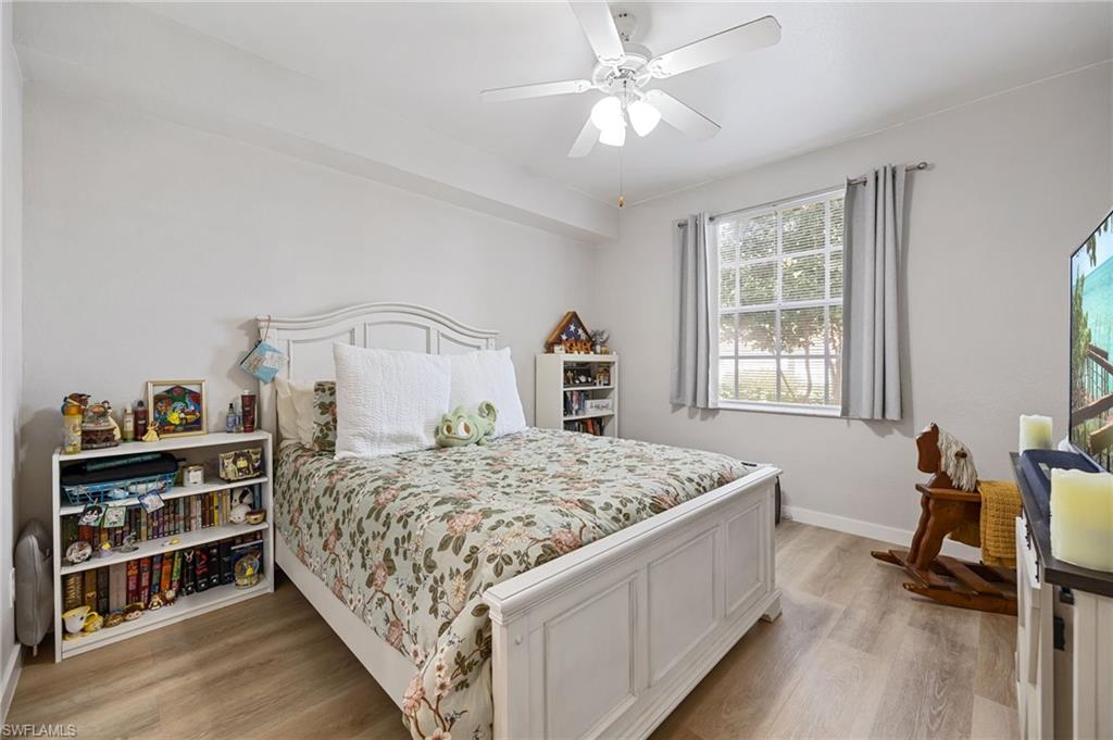 4710 St Croix Lane, Unit 216 Naples, FL 34109 - Photo 17 of 29 a bedroom with a bed and a chandelier