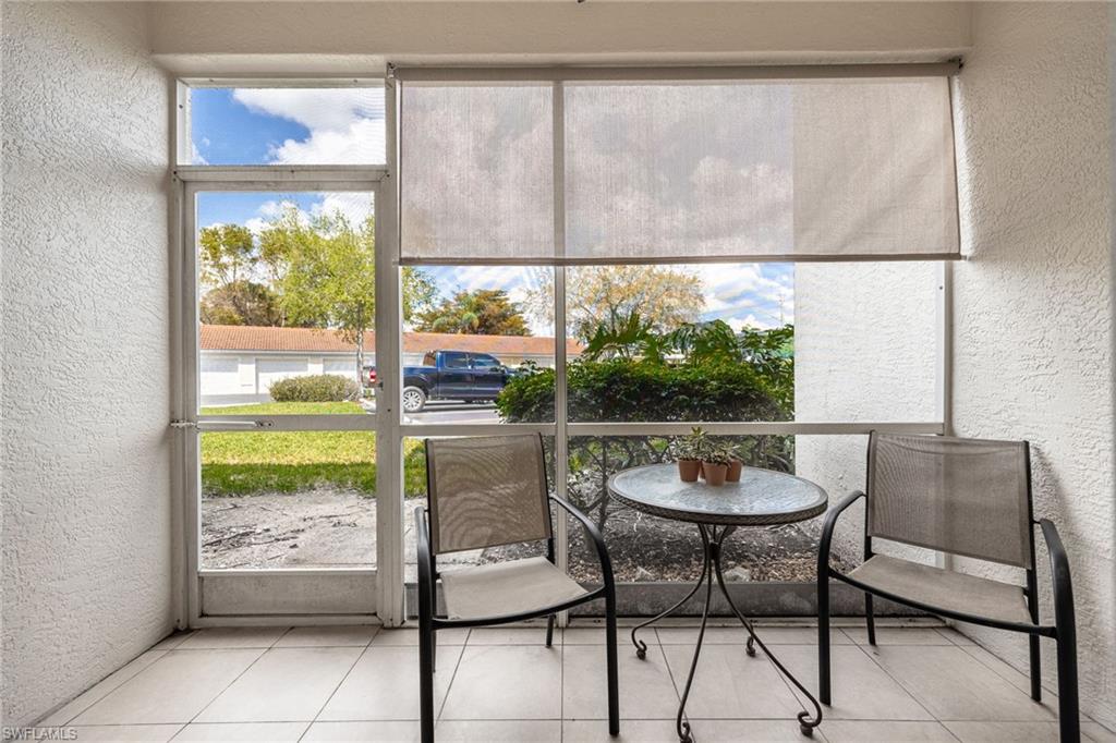 4710 St Croix Lane, Unit 216 Naples, FL 34109 - Photo 22 of 29 a room with a large window and a table chair