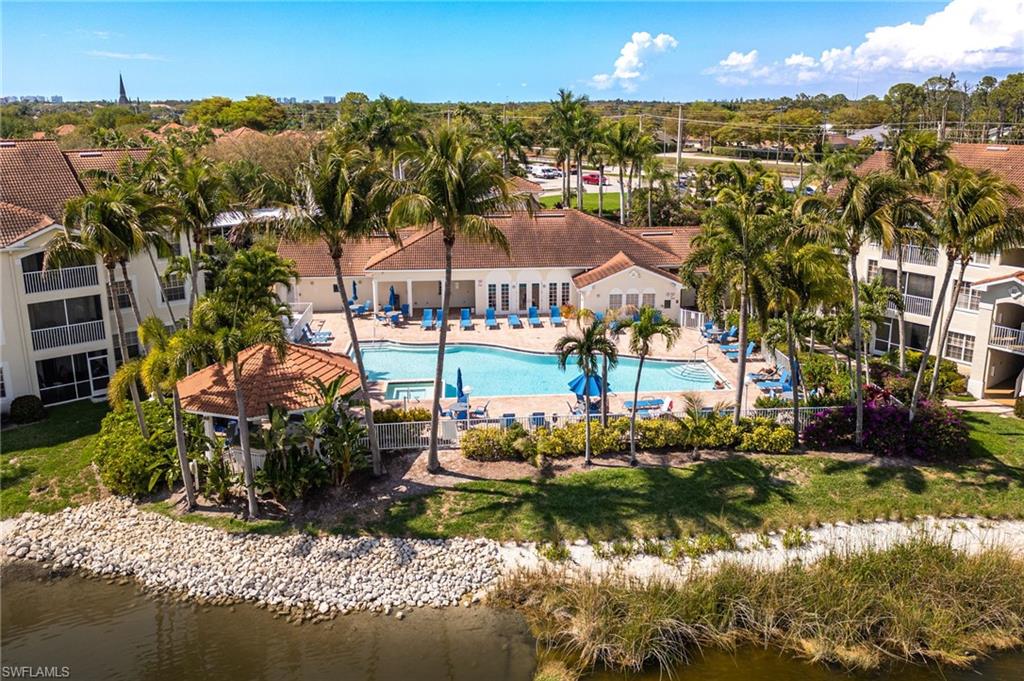 4710 St Croix Lane, Unit 216 Naples, FL 34109 - Photo 25 of 29 a front view of a house with a yard and lake view