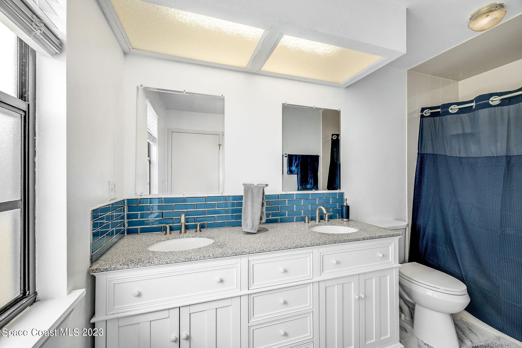 4505 Comfort Street Cocoa, FL 32927 - Photo 17 of 30 a bathroom with a granite countertop sink and a mirror