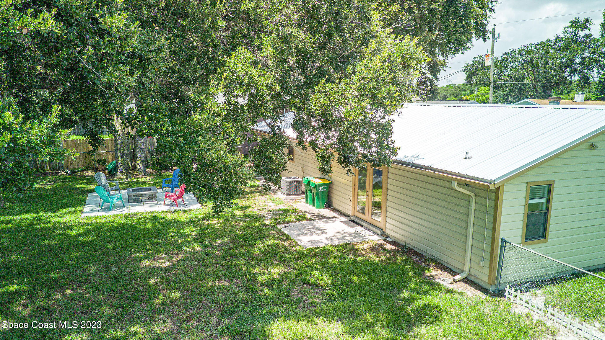 4505 Comfort Street Cocoa, FL 32927 - Photo 21 of 30 a backyard of a house with table and chairs and a large tree