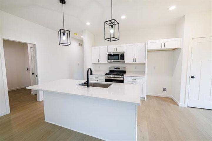 14212 Prairie Commons Lane South Beloit, IL 61080 - Photo 5 of 23 a kitchen with stainless steel appliances a stove a sink and a refrigerator