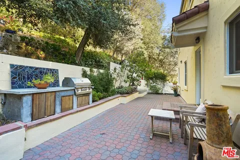 a view of a patio with couches table and chairs and potted plants