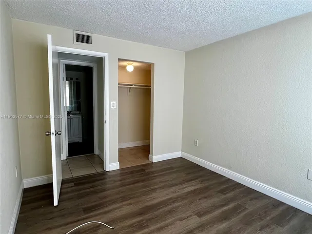 an empty room with wooden floor and closet