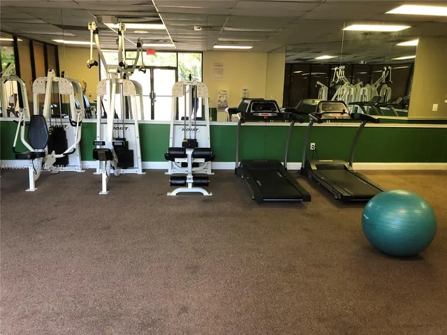 a room with gym equipment and large mirror