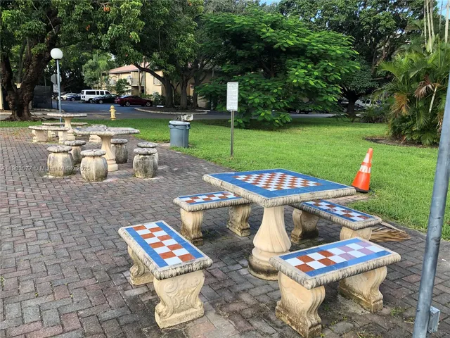 a view of a chairs and table in backyard with a fountain