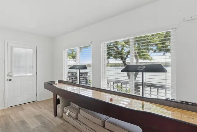 a view of a workspace room with wooden floor and windows