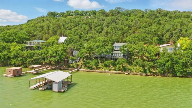 a view of a swimming pool with lawn chairs and plants