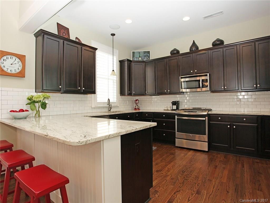 409 Hollyhock Lane Fort Mill, SC 29708 - Photo 8 of 24 a kitchen with stainless steel appliances granite countertop a stove a sink dishwasher and a refrigerator with wooden cabinets