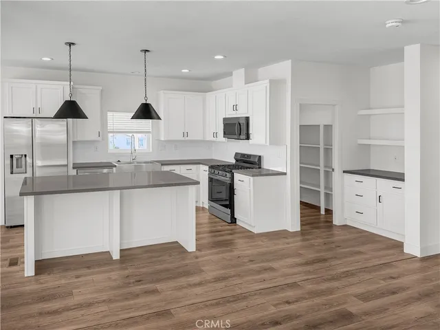 a kitchen with stainless steel appliances granite countertop a stove a sink and a refrigerator