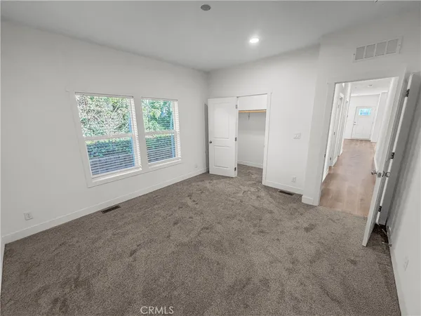 an empty room with windows and closet