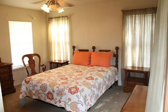 a bedroom with a bed and a flat tv screen on the dresser