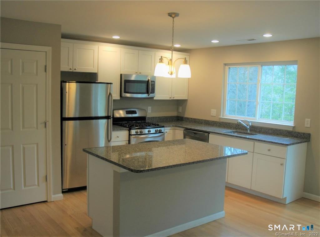 16 Riverview Court, Unit 16 Brookfield, CT 06804 - Photo 1 of 1 a kitchen with stainless steel appliances granite countertop a sink a stove a refrigerator a center island and couches