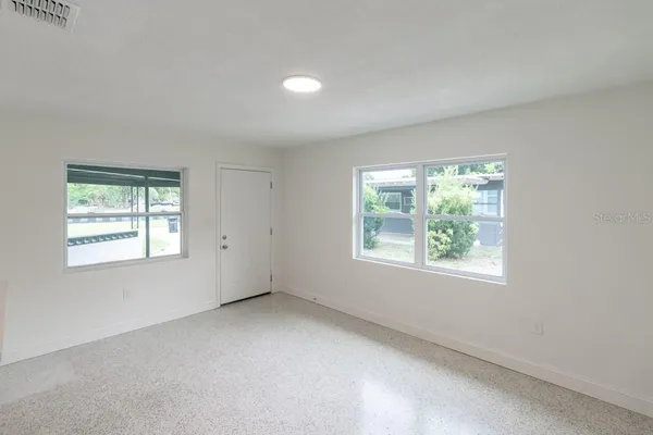 a kitchen with white cabinets and refrigerator