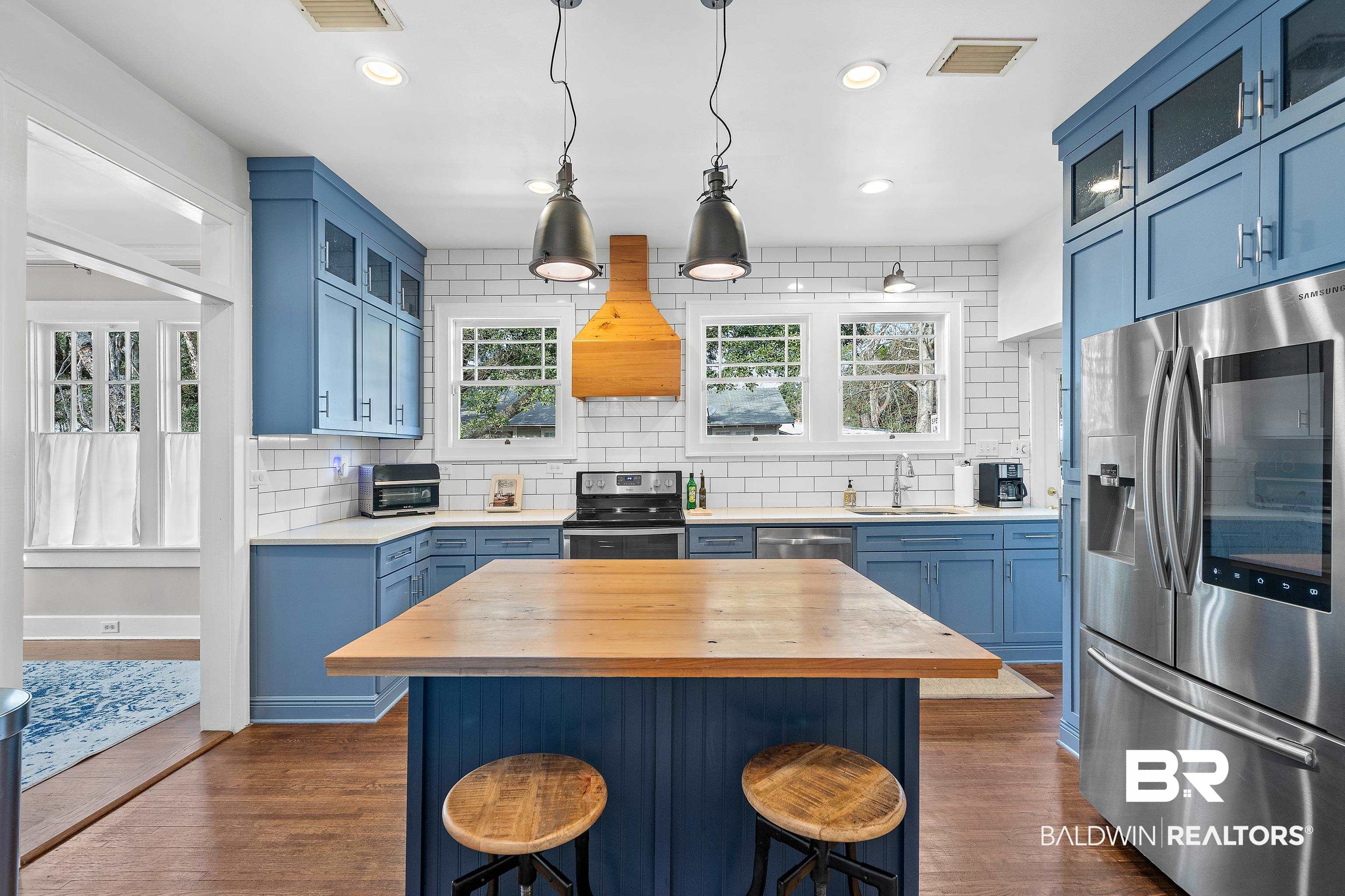 111 Macy Place Mobile, AL 36604 - Photo 12 of 35 The Kitchen features stainless steel appliances, a center island with reclaimed wood and striking blue cabinetry