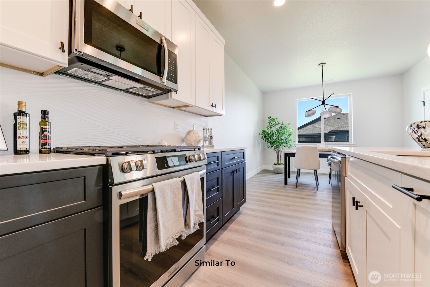523 North Lessor Loop Moses Lake, WA 98837 - Photo 10 of 25 a kitchen with stainless steel appliances a stove a microwave and white cabinets