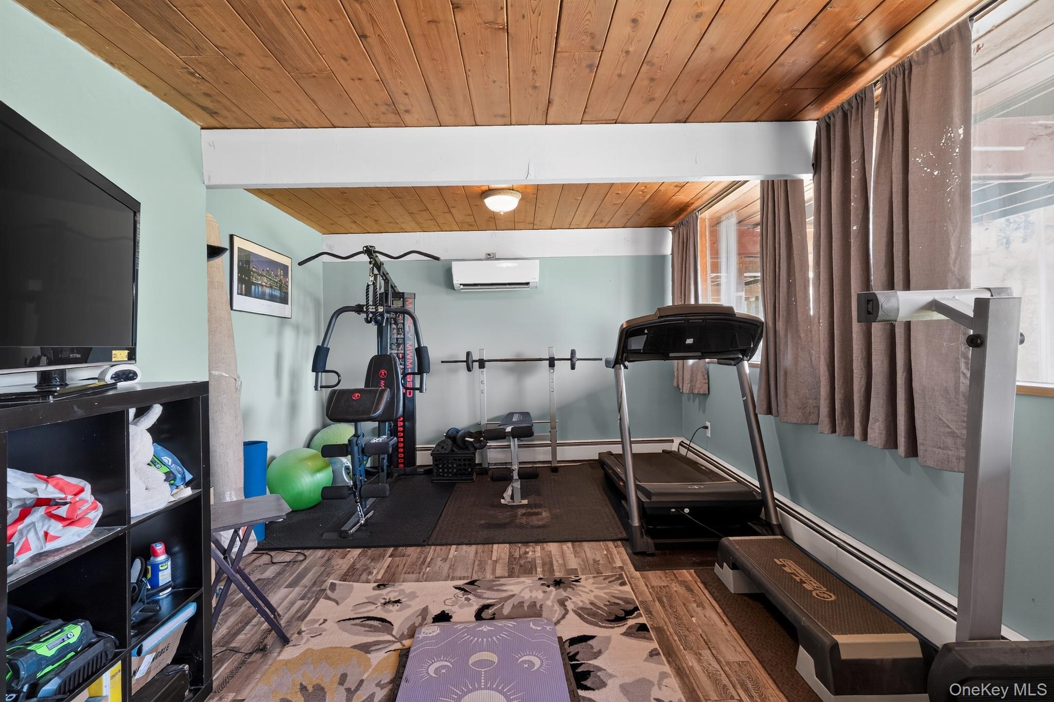 424 Laroe Road Chester, NY 10918 - Photo 41 of 43 Room featuring wood-finish flooring, a wood-paneled ceiling with exposed white beams, and light blue walls