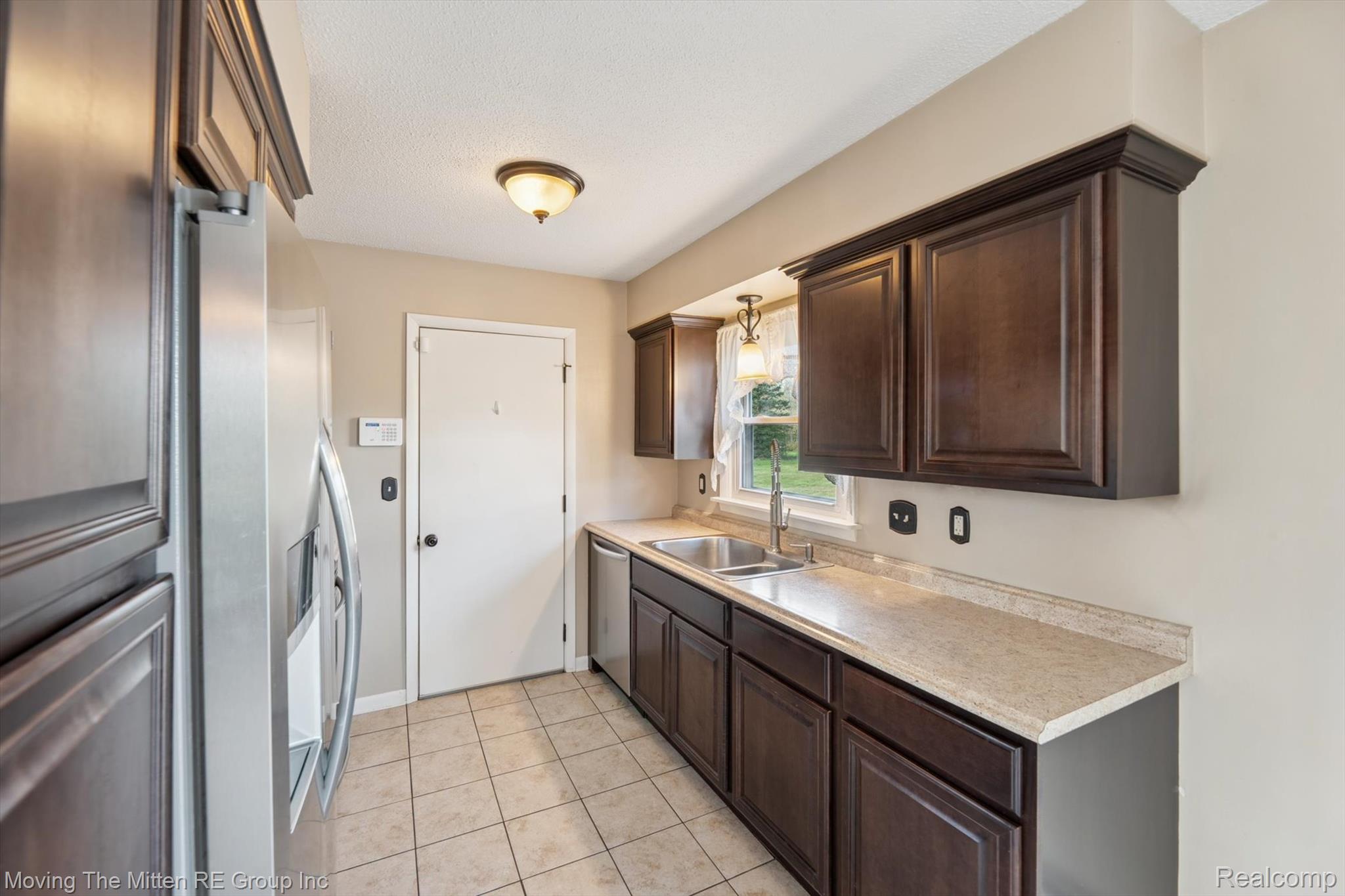 12000 Plank Road Milan, MI 48160 - Photo 10 of 49 Kitchen with dark wood finish cabinets, stainless steel appliances, light countertops, and light tile patterned floors