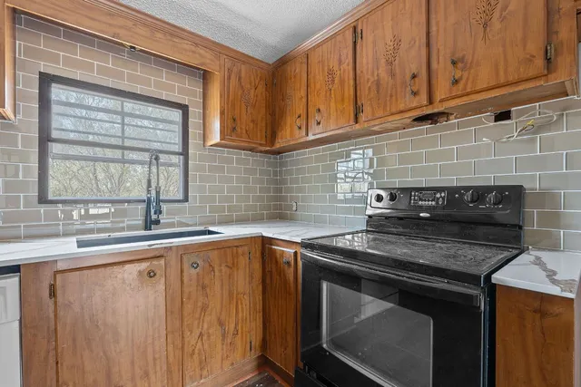 a kitchen with stainless steel appliances granite countertop a sink stove and cabinets