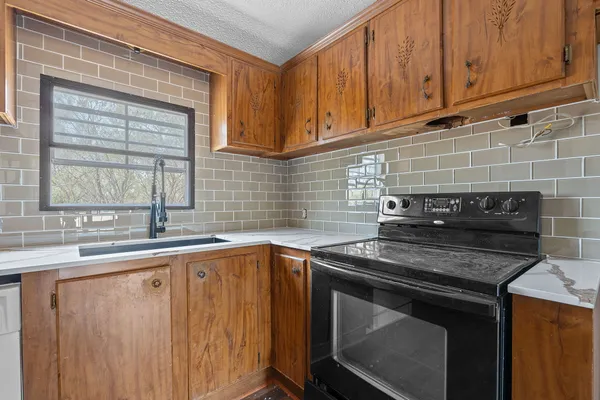 a kitchen with stainless steel appliances granite countertop a sink stove and cabinets
