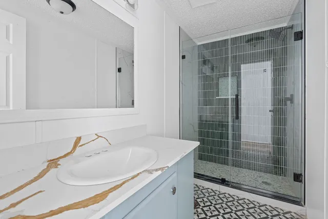 a bathroom with a shower sink and mirror