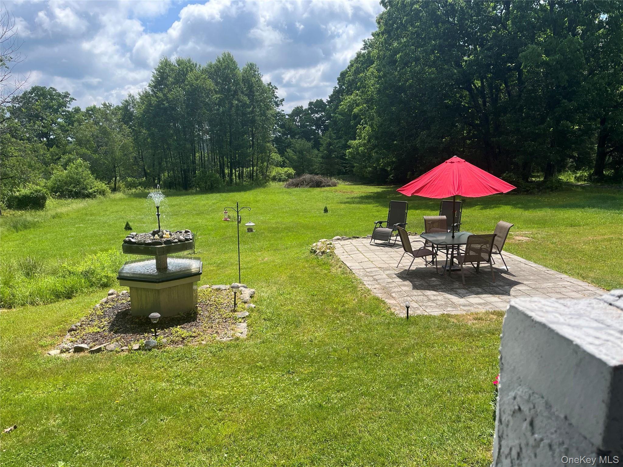 97 Rauch Road Lake Huntington, NY 12752 - Photo 34 of 35 a view of a patio with a table and chairs under an umbrella