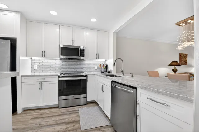 a kitchen with appliances a sink and cabinets