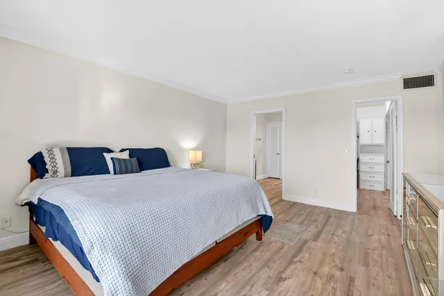 a bedroom with bed and wooden floor