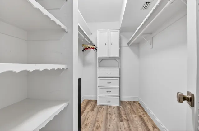a view of walk in closet with clothes and shoes