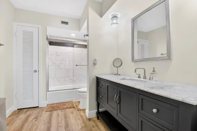 a bathroom with a granite countertop sink toilet and shower