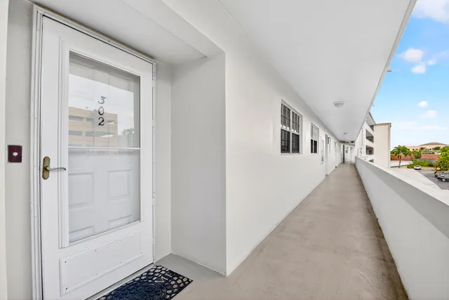 a view of a hallway with white walls and stairs