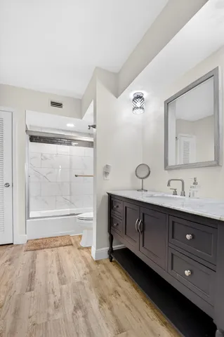 a spacious bathroom with a granite countertop sink mirror and bathtub