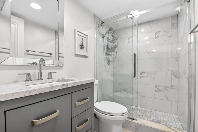 a bathroom with a sink a toilet and shower