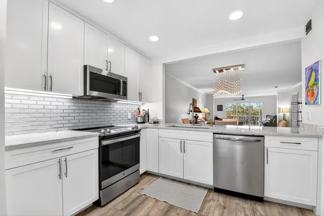 a kitchen with cabinets stainless steel appliances and a sink