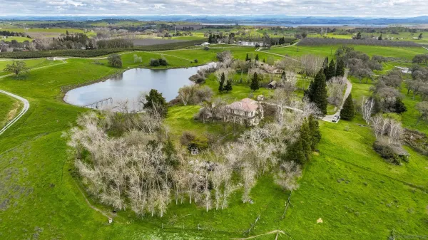 a kitchen with stainless steel appliances granite countertop a dining table and chairs with wooden floor