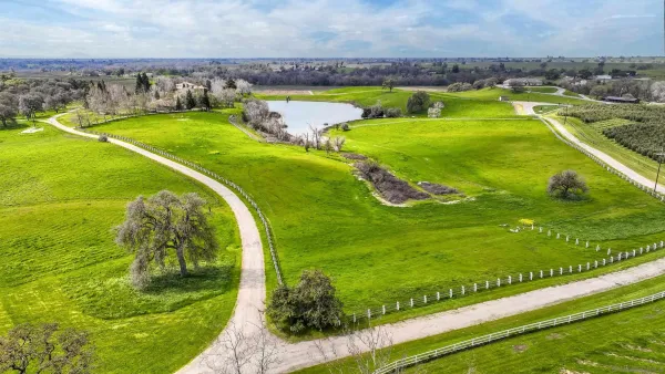a kitchen with stainless steel appliances granite countertop a sink a stove a counter space and a window